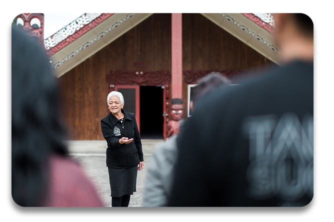 Kaikaranga standing in front of the marae