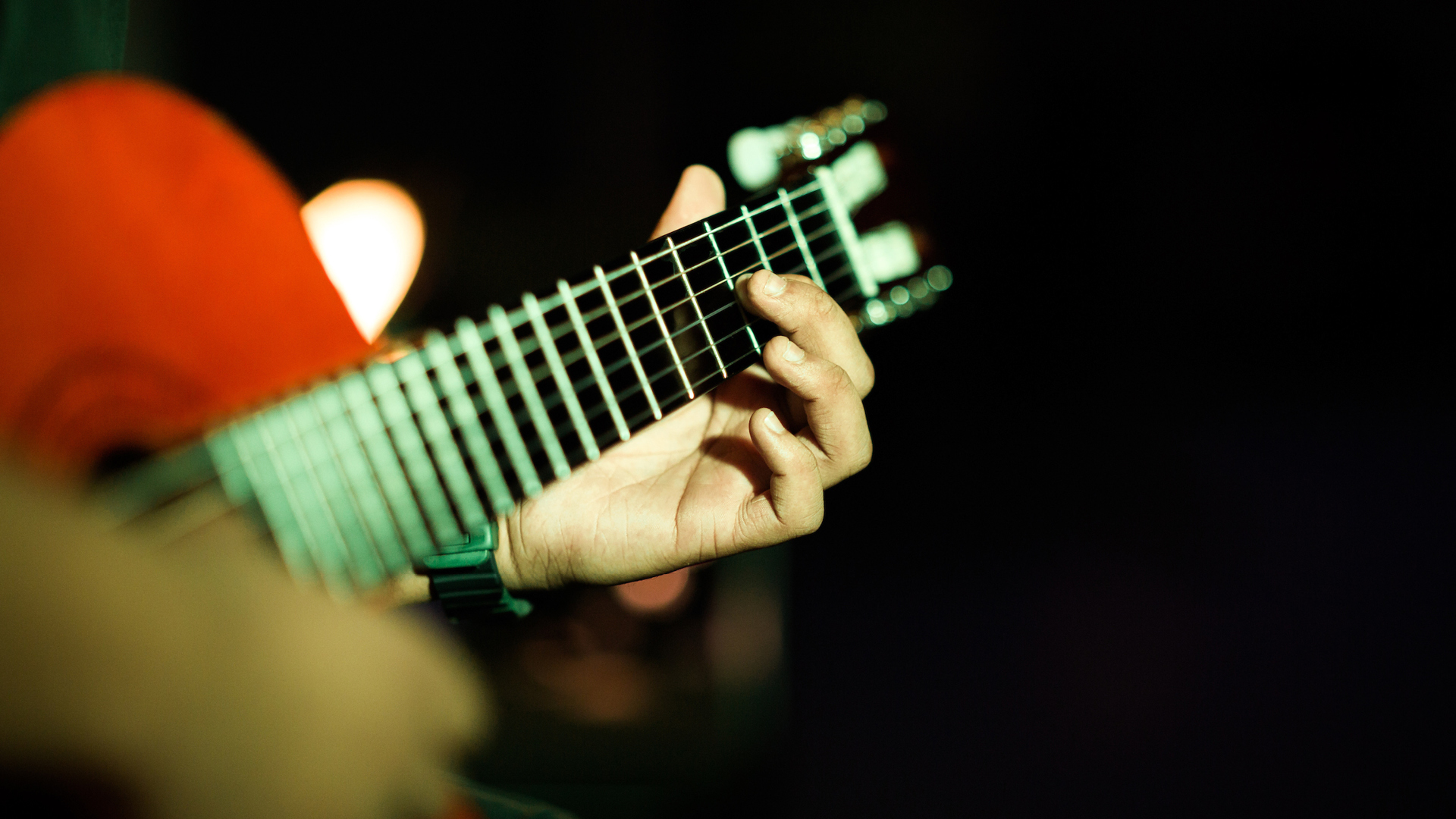 Close up of hands playing an acoustic guitar.