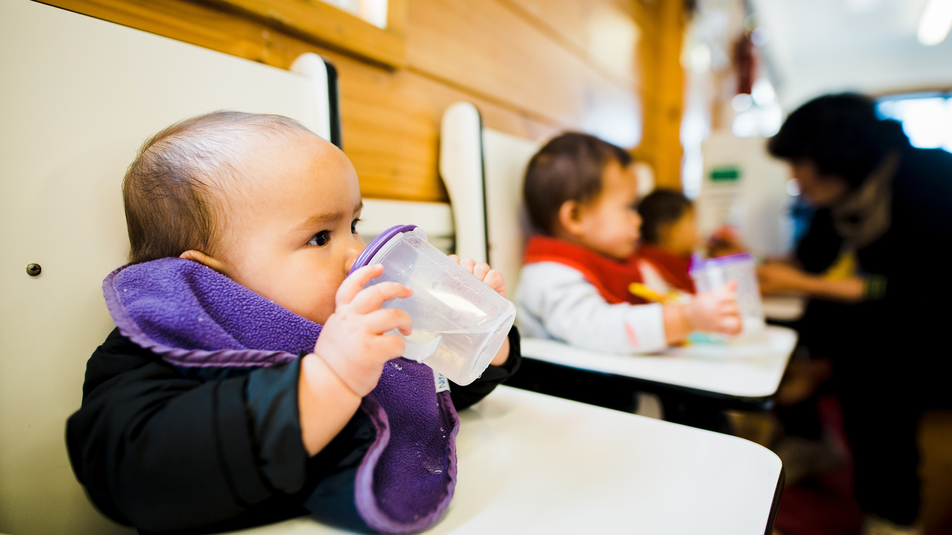 Baby drinking water in highchair at ELC