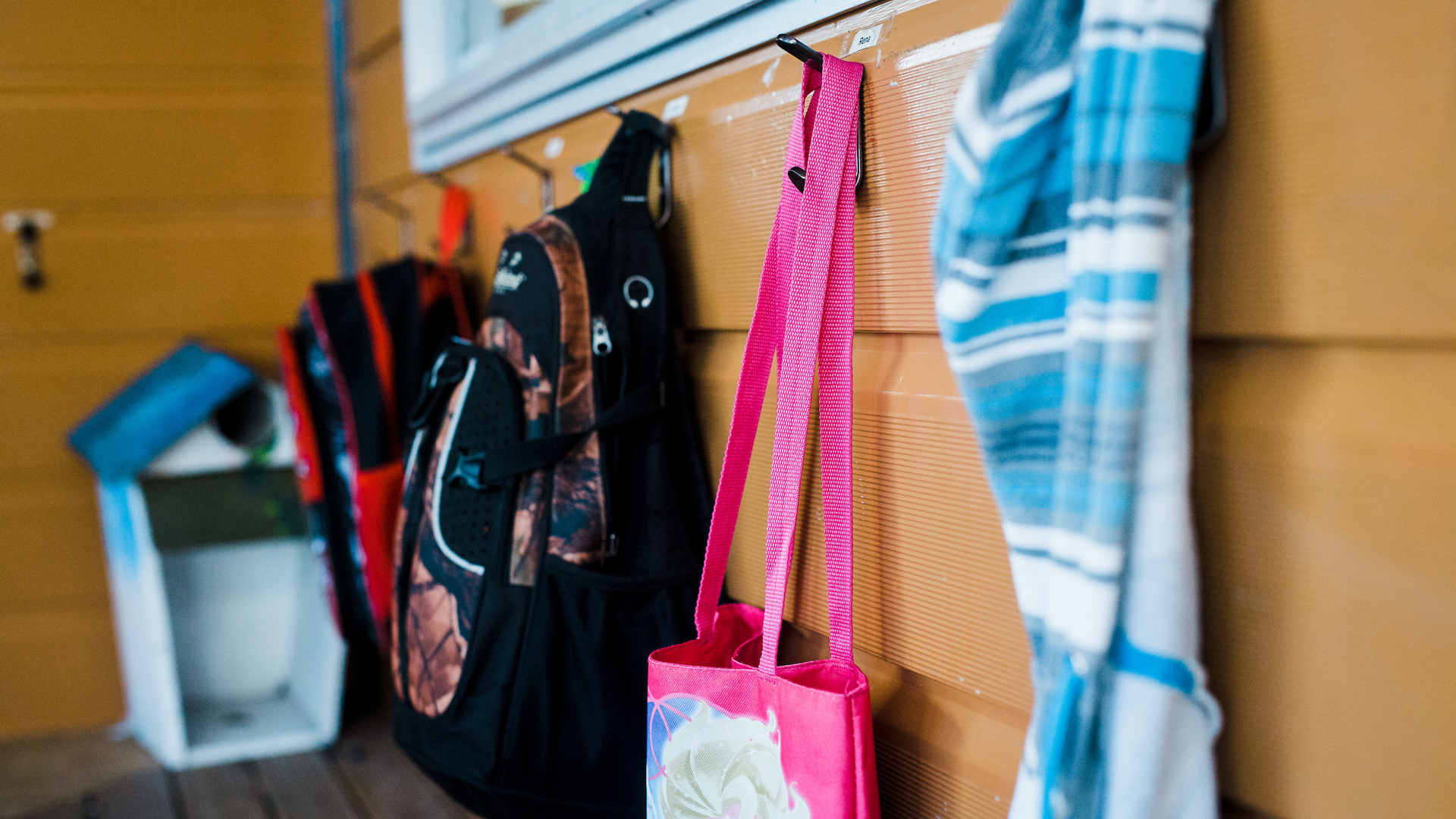 School bags hanging on wall hooks