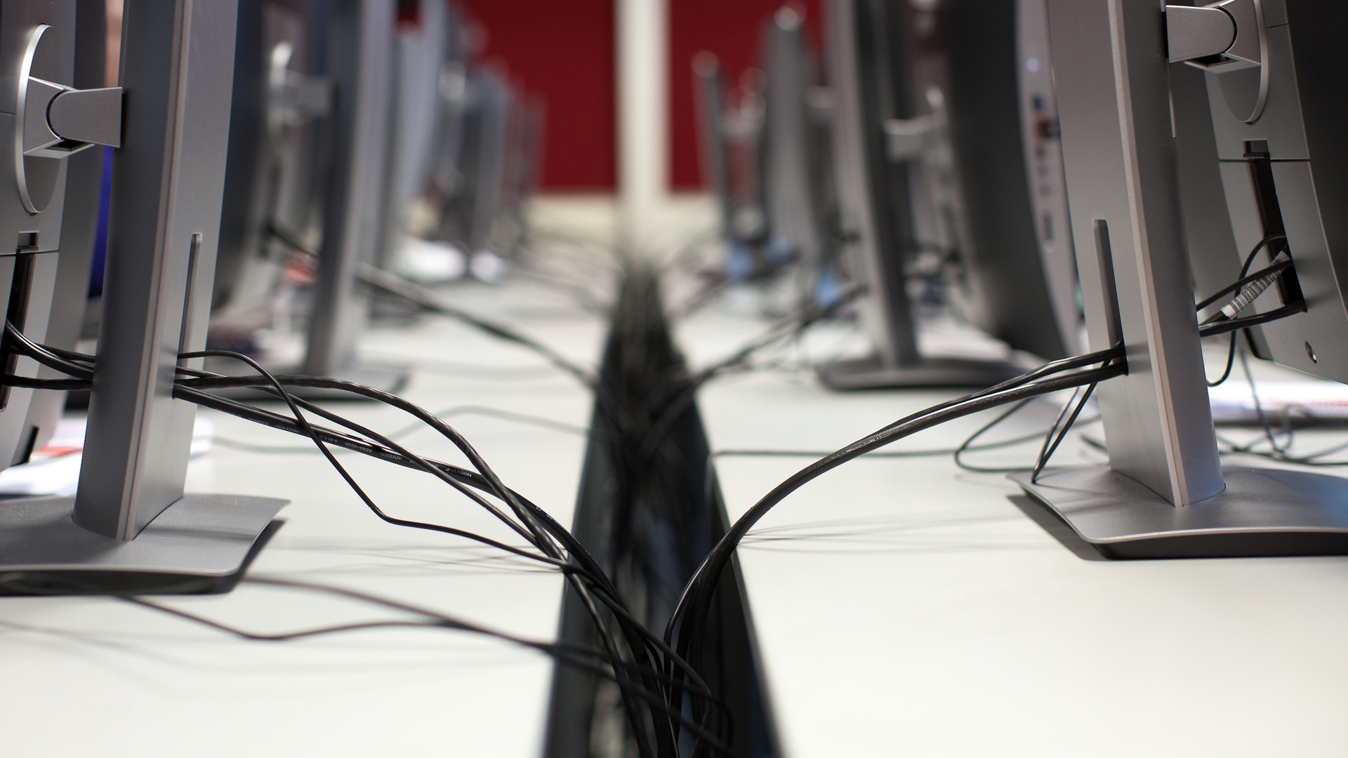 Close up view of cables between two rows of computer desks