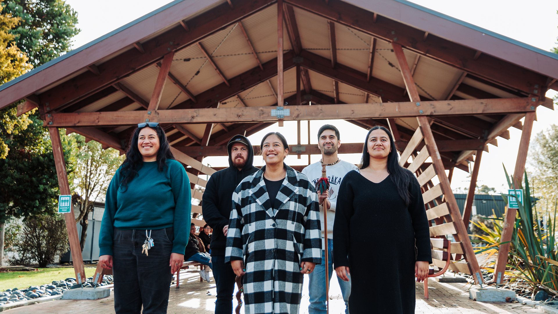 A group of people welcome guests through the marae entrance