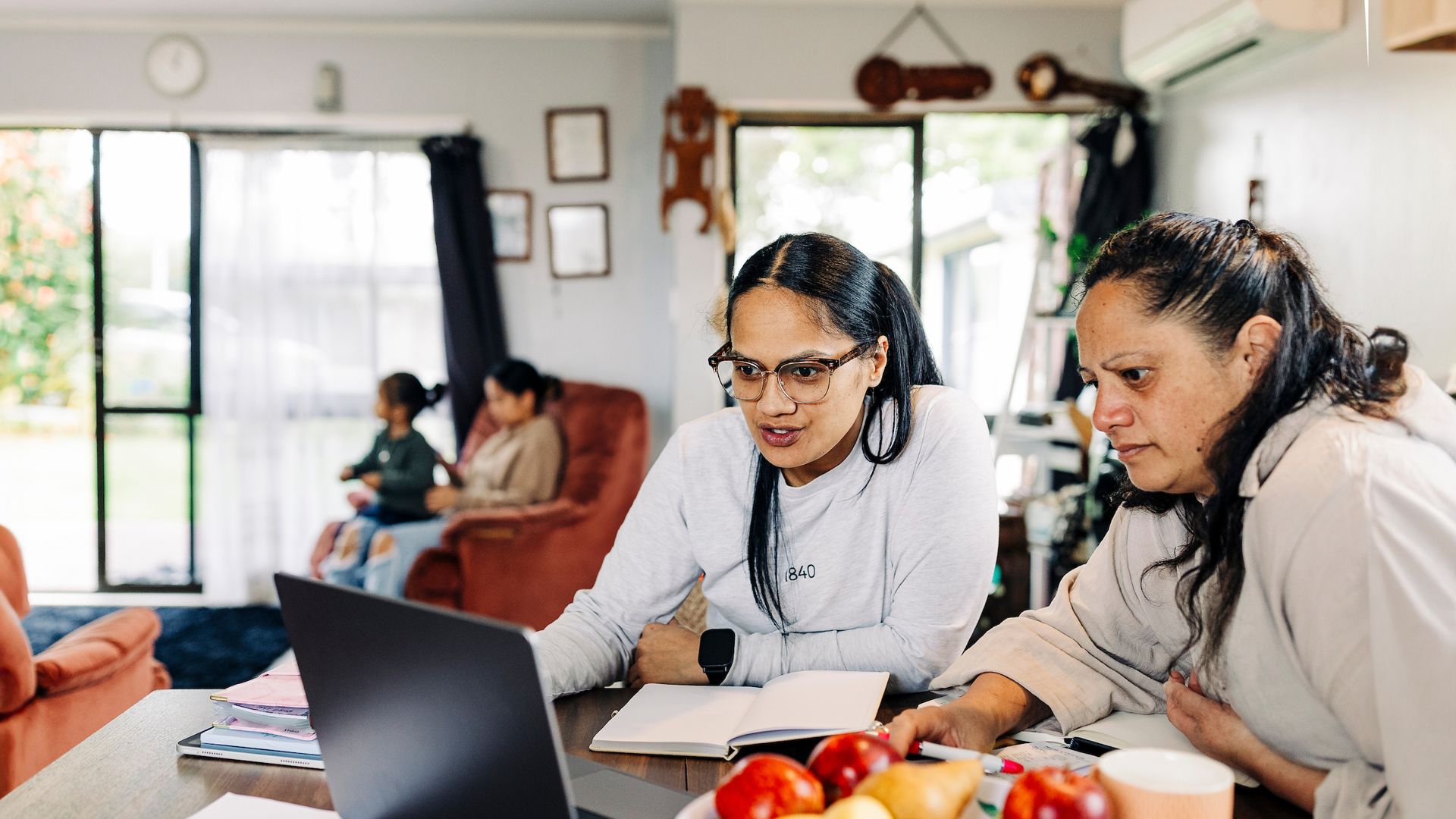 Two women using a laptop at the dining table