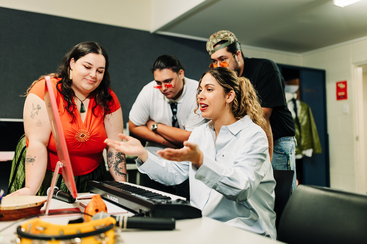 A group of Māori performing arts students discuss music production in the studio