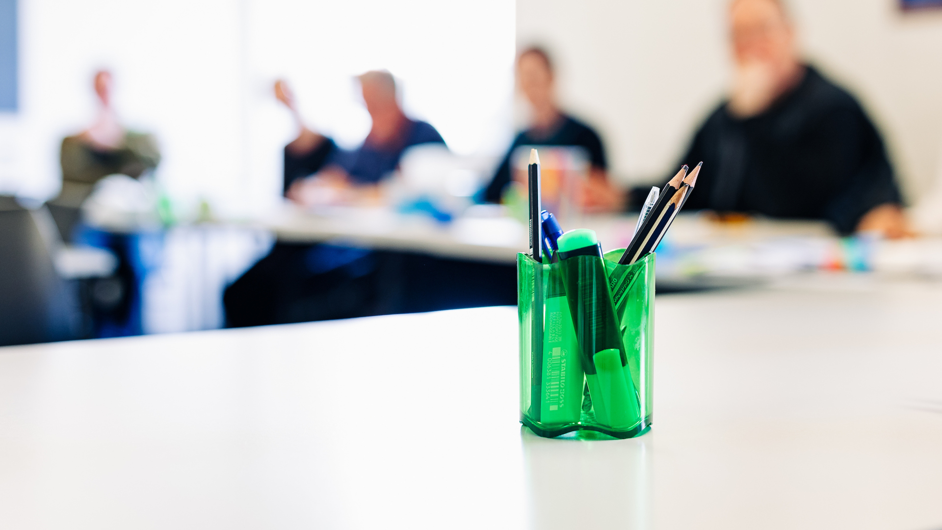 Close up of a pencil holder on a classroom table