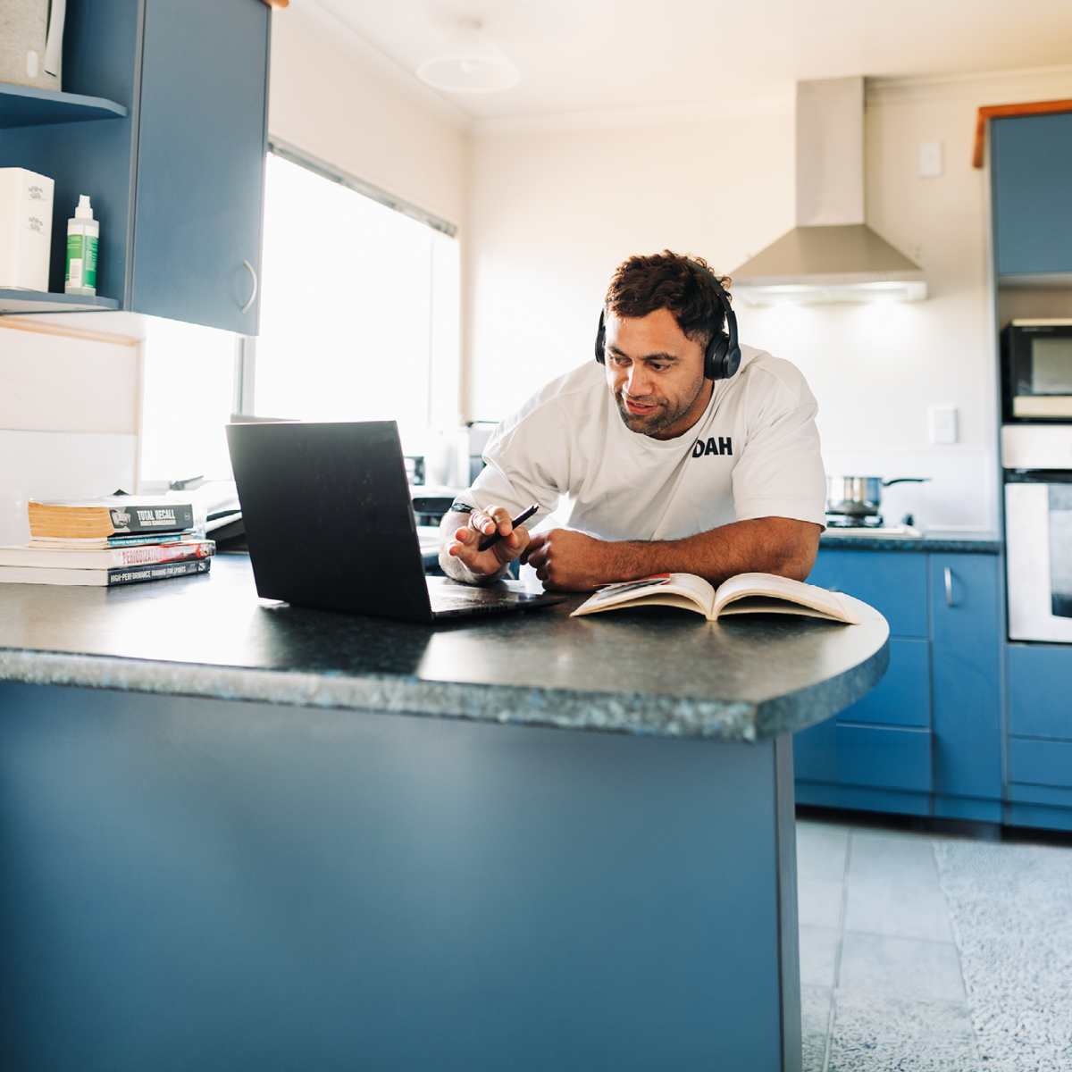 Man studying on laptop in home kitchen