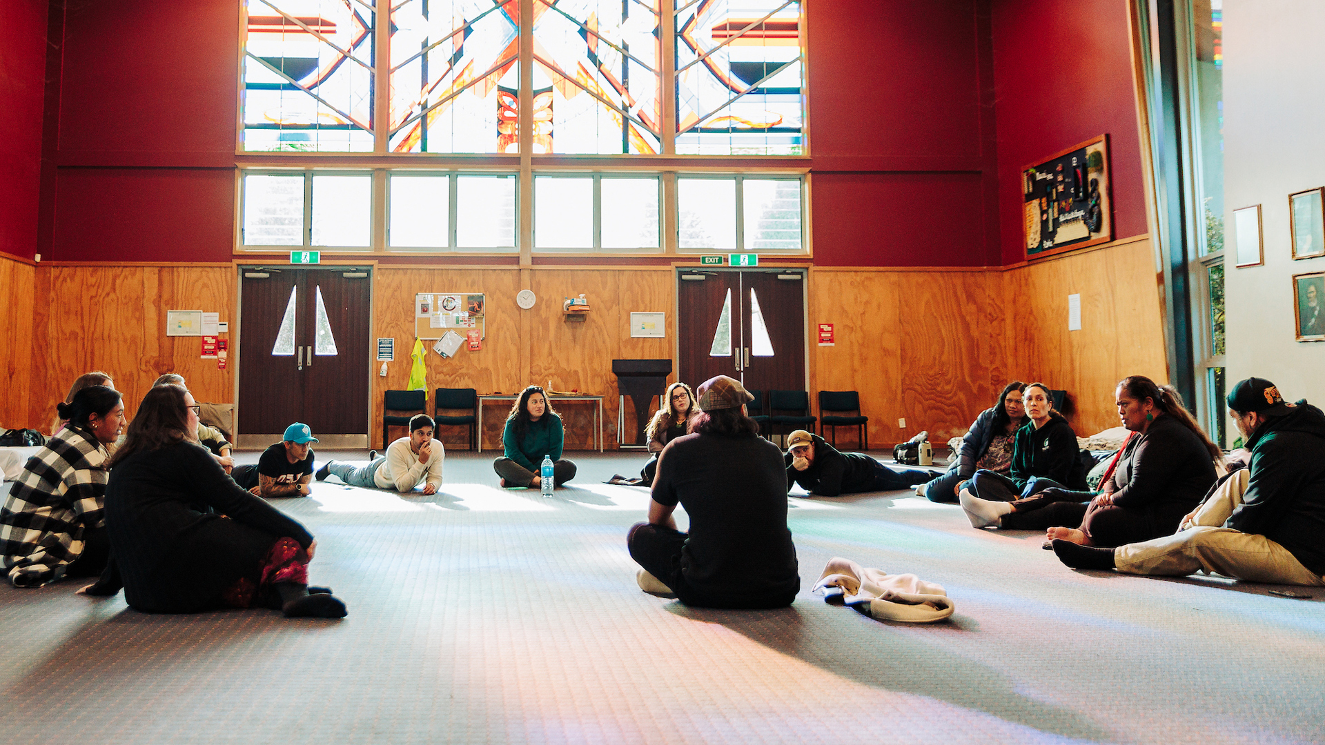 A group of students sitting in a circle have a wānanga in the wharenui