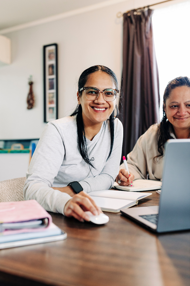 Two women using a laptop at the dining table