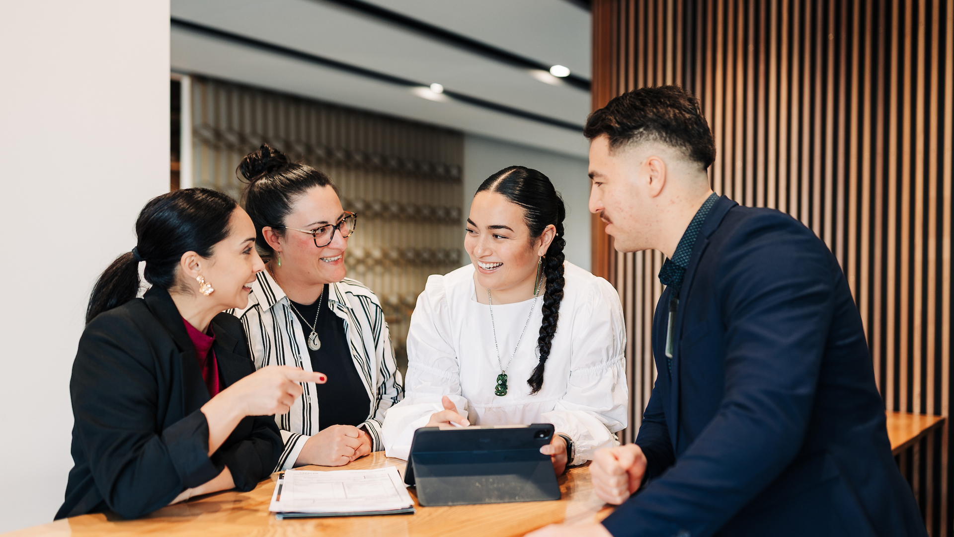 Four professionals in an office have a discussion