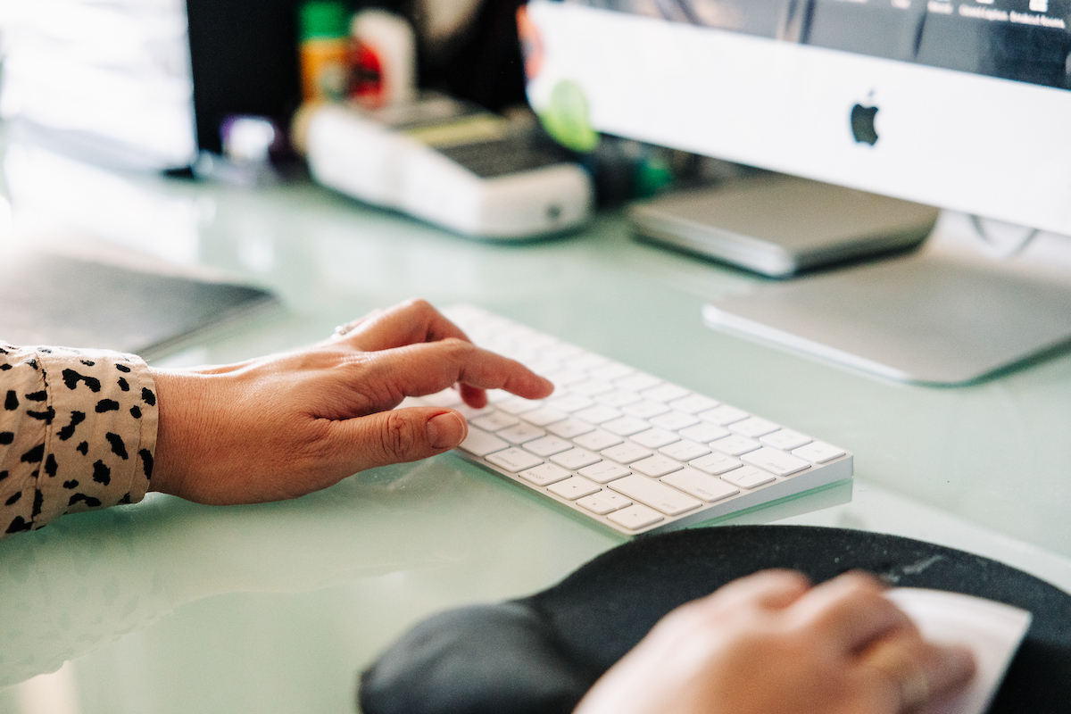 Hands typing on a computer keyboard