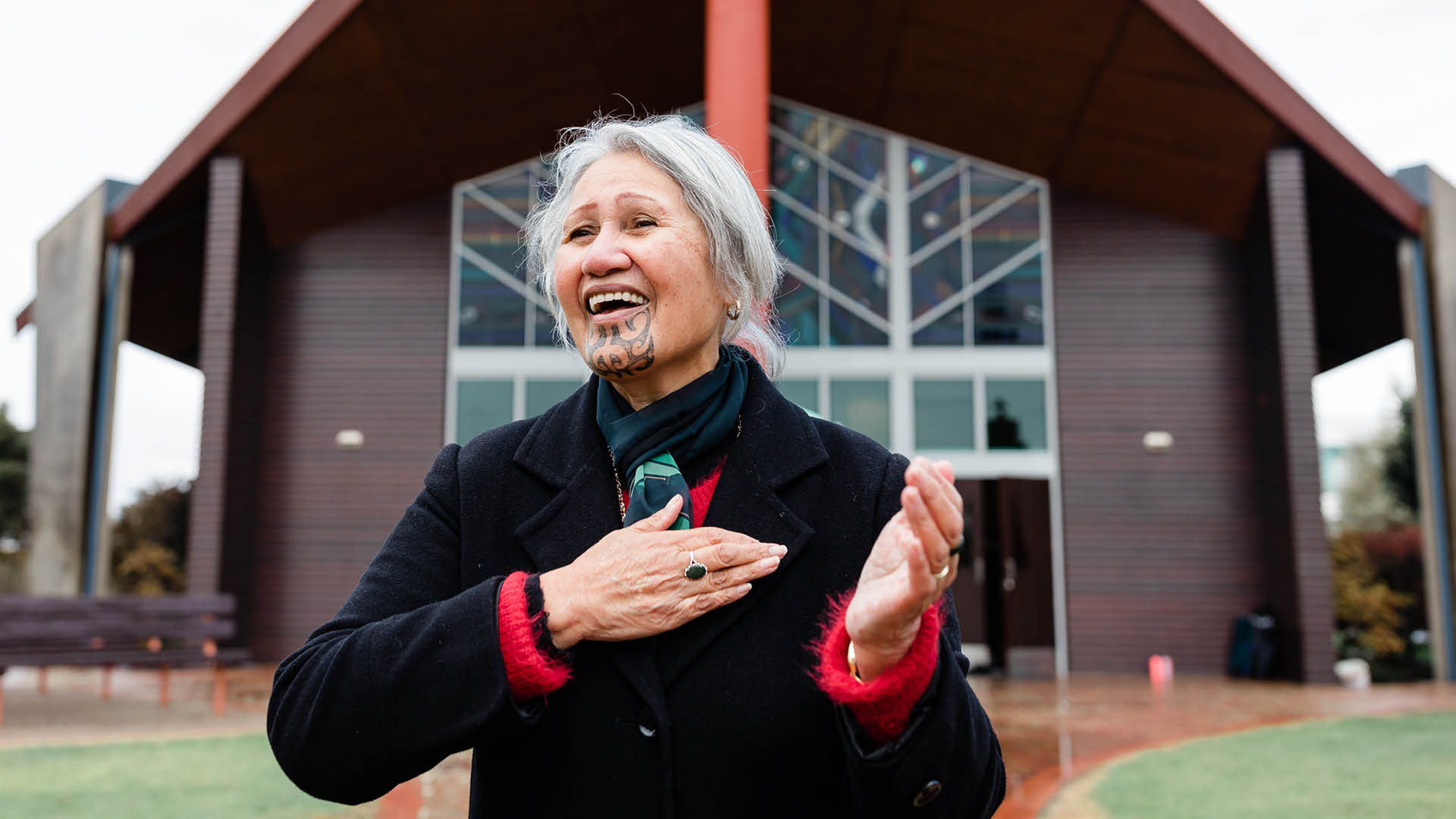 Te Wānanga o Aotearoa_Te Tirohanga Maori_Te Whāinga o te Ao Tikanga. Older woman performing a karanga outside a building. 