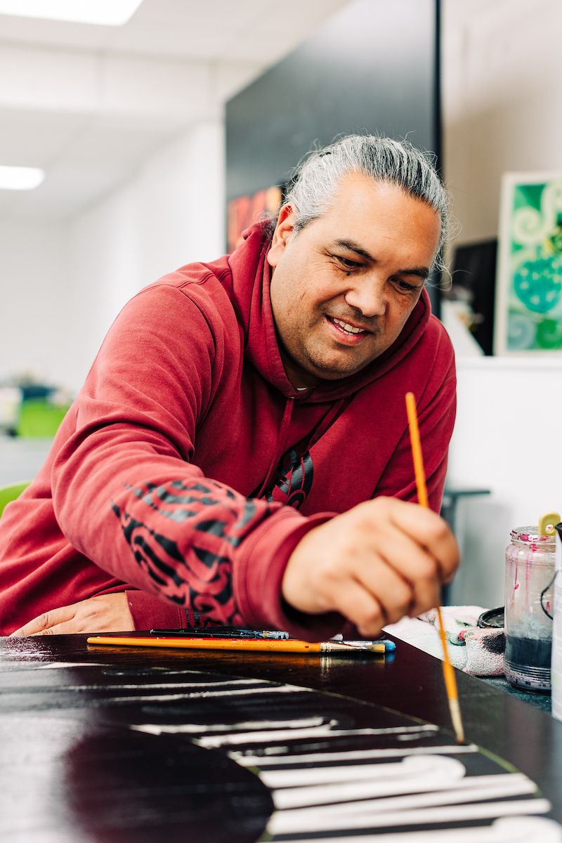 A Toi student paints their artwork
