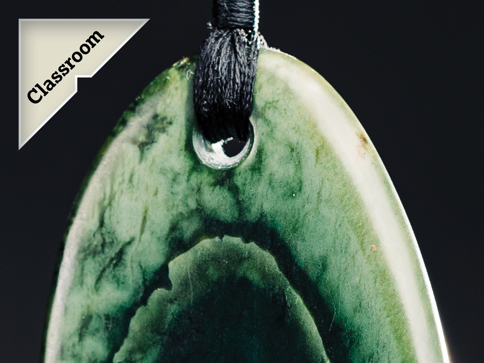 A close up photo of a pounamu pendant with a callout badge saying 'Classroom'